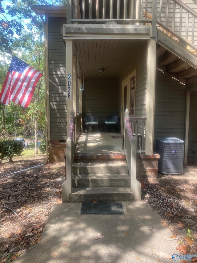 doorway to property featuring a porch and cooling unit