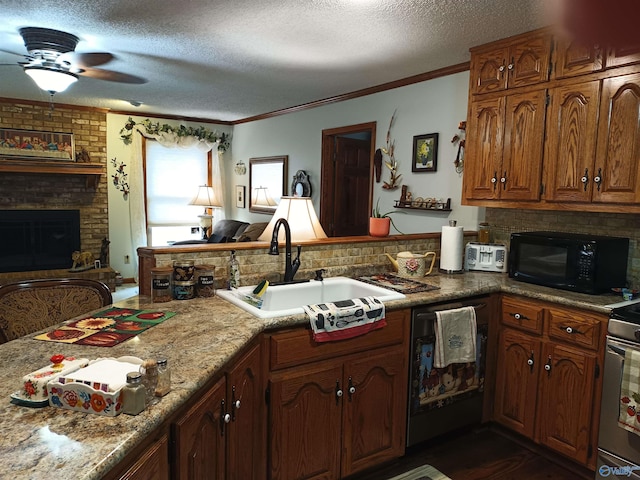 kitchen with sink, crown molding, a textured ceiling, a brick fireplace, and black appliances