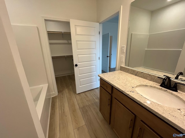 bathroom featuring vanity, a shower, and wood-type flooring