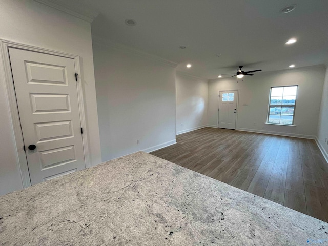 empty room featuring ceiling fan, dark hardwood / wood-style flooring, and ornamental molding