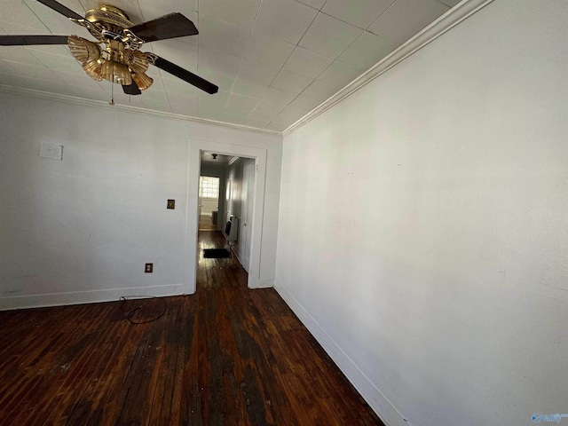 unfurnished room with ceiling fan, baseboards, ornamental molding, and dark wood finished floors