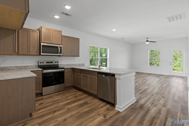 kitchen with a peninsula, visible vents, stainless steel appliances, and a sink