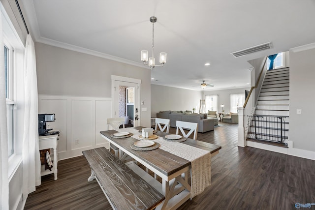 dining space featuring visible vents, dark wood-style floors, stairway, ornamental molding, and a decorative wall