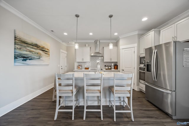 kitchen featuring wall chimney exhaust hood, appliances with stainless steel finishes, light countertops, white cabinetry, and pendant lighting