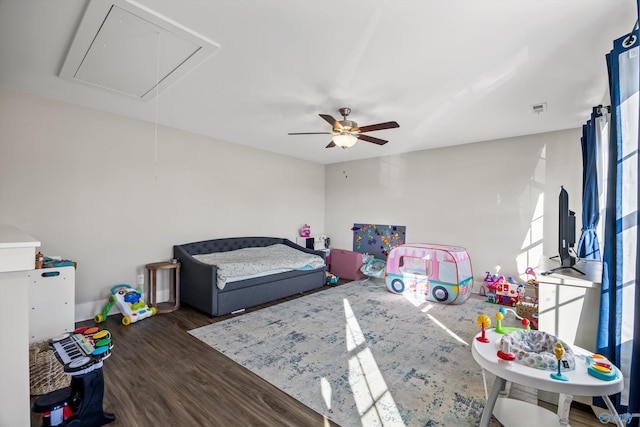 bedroom with ceiling fan, attic access, multiple windows, and dark wood finished floors