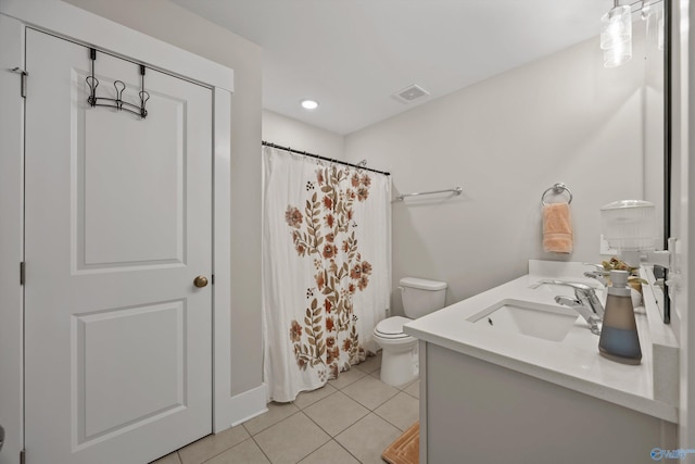 bathroom featuring toilet, a sink, visible vents, tile patterned floors, and double vanity