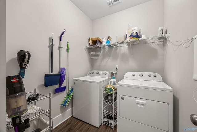 clothes washing area with laundry area, baseboards, visible vents, dark wood finished floors, and washer and dryer