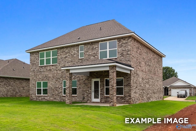 rear view of property featuring brick siding, a yard, and a patio