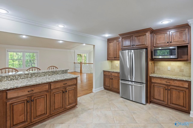 6824 Criner Rd SE, Huntsville, AL 35802 - kitchen with appliances with stainless steel finishes, healthy amount of natural light, tasteful backsplash, crown molding, and light stone counters