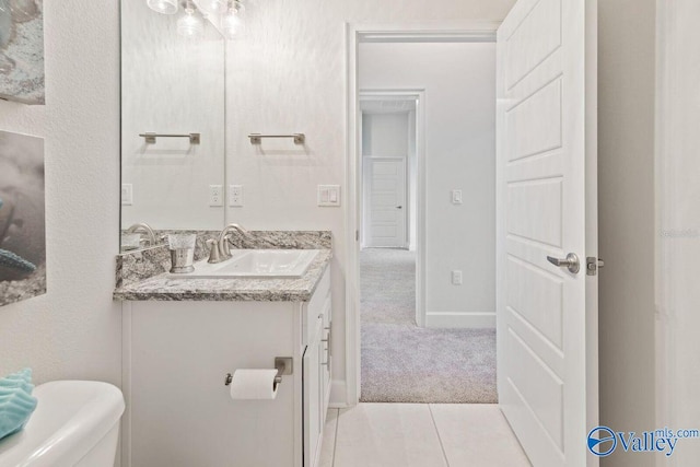 bathroom featuring toilet, vanity, and baseboards