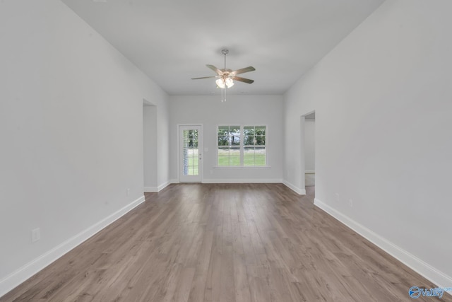 empty room featuring ceiling fan, baseboards, and wood finished floors