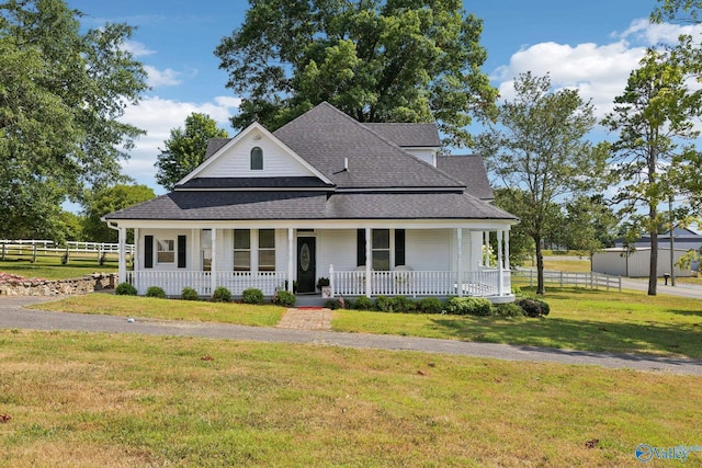 farmhouse-style home featuring a porch and a front yard