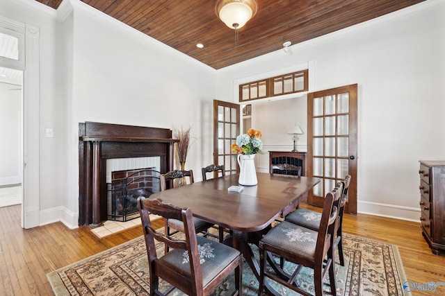 dining area with crown molding, light hardwood / wood-style flooring, and wood ceiling