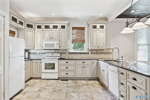 kitchen featuring dark stone counters, ornamental molding, white appliances, sink, and hanging light fixtures