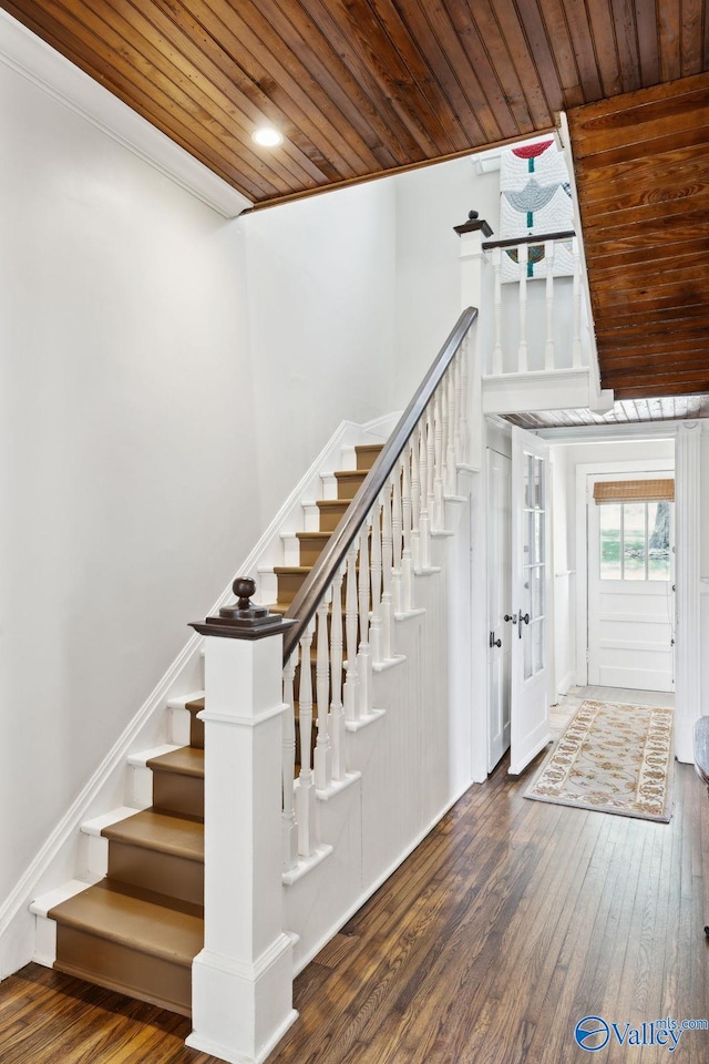 staircase featuring hardwood / wood-style flooring, crown molding, and wooden ceiling