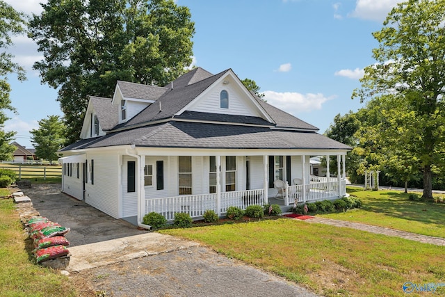 country-style home with covered porch and a front yard