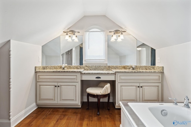 bathroom with a bath, wood-type flooring, vanity, and vaulted ceiling