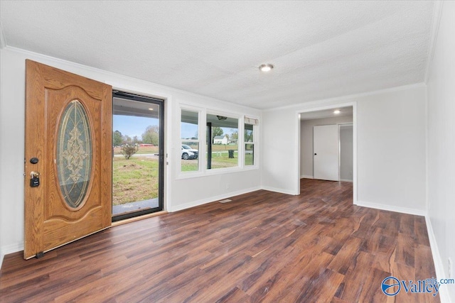 entrance foyer with a textured ceiling, dark hardwood / wood-style flooring, and crown molding