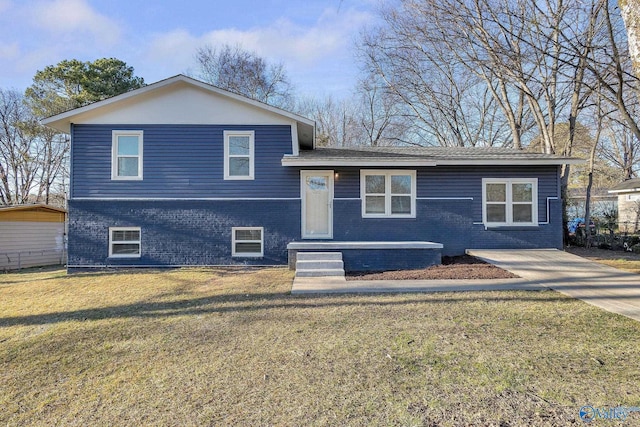 tri-level home with a front lawn and brick siding