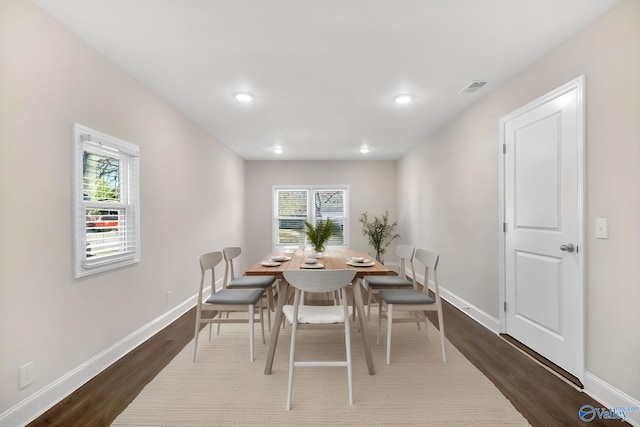 dining space featuring dark wood finished floors, visible vents, and baseboards