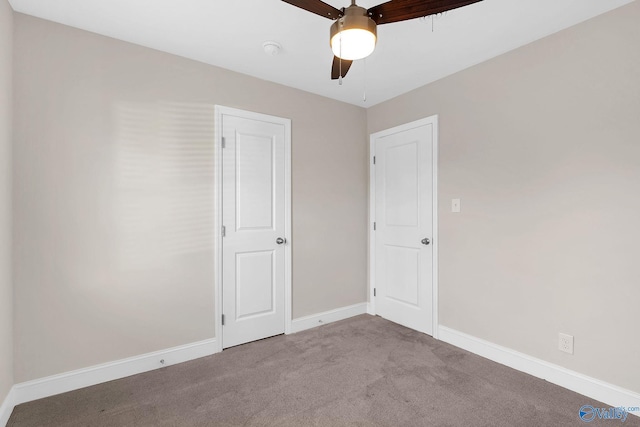 carpeted empty room with baseboards and ceiling fan