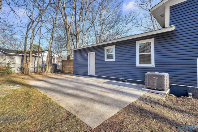 view of outbuilding with fence and central AC