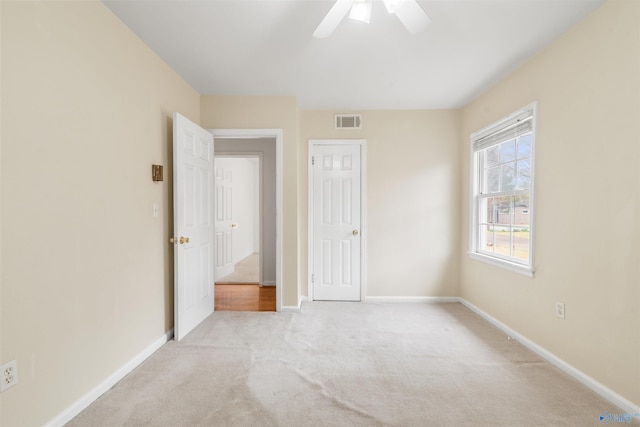 unfurnished bedroom with carpet flooring, baseboards, visible vents, and ceiling fan