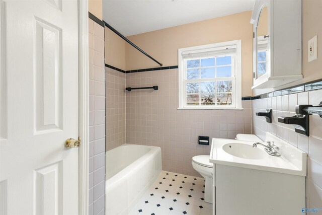 full bathroom with toilet, vanity, tile walls, and bathing tub / shower combination