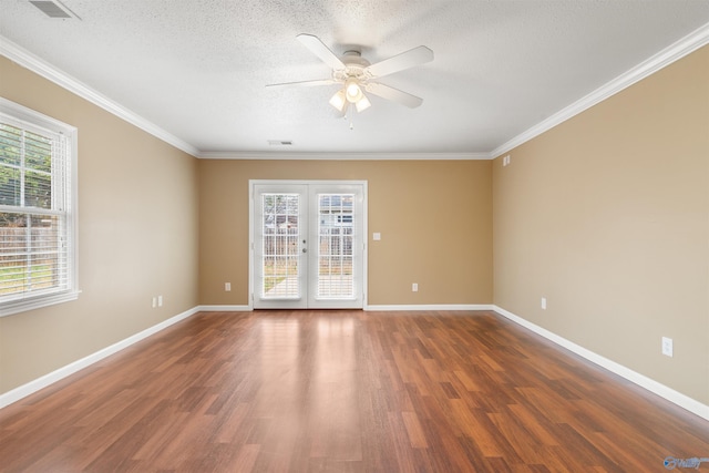 spare room with wood finished floors, french doors, baseboards, and ornamental molding