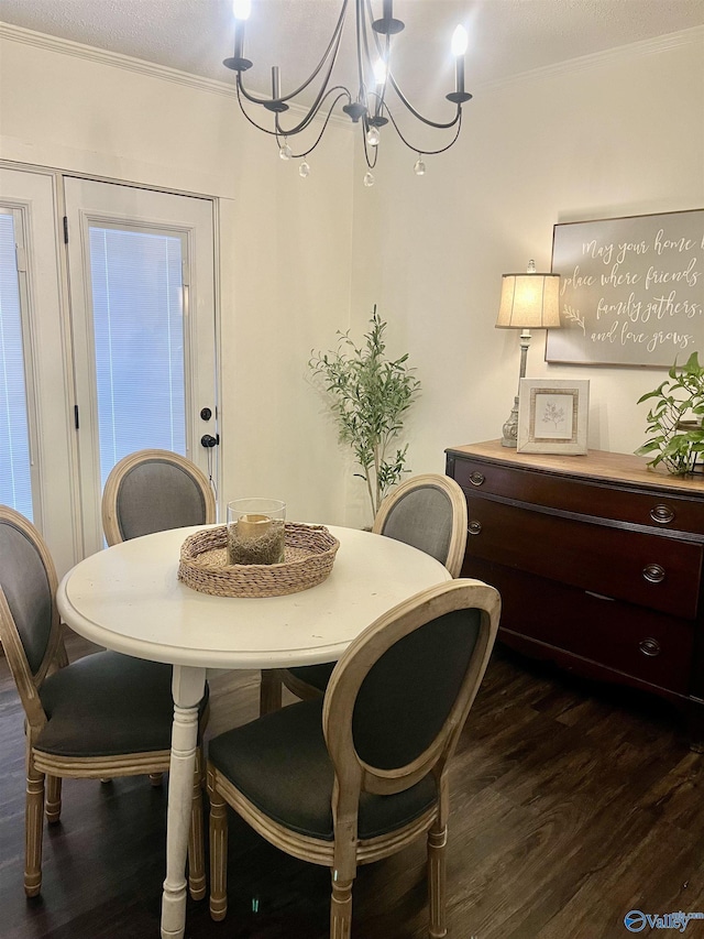 dining space with crown molding, an inviting chandelier, a textured ceiling, and dark hardwood / wood-style flooring