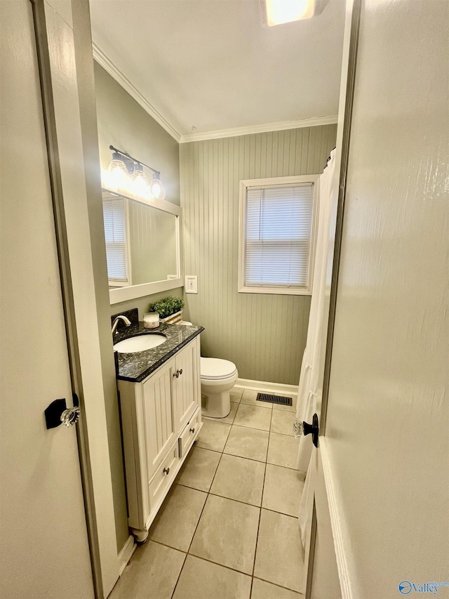 bathroom featuring tile patterned flooring, vanity, ornamental molding, toilet, and wood walls