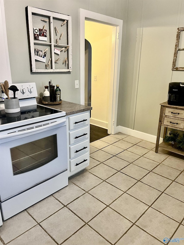 kitchen featuring light tile patterned flooring and white range with electric stovetop