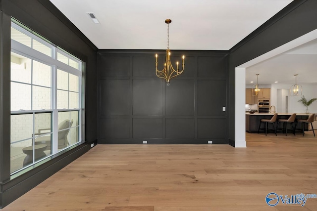 60 Trail Loop Rd, Huntsville, AL 35803 - dining area featuring a decorative wall, a chandelier, light wood-type flooring, and crown molding