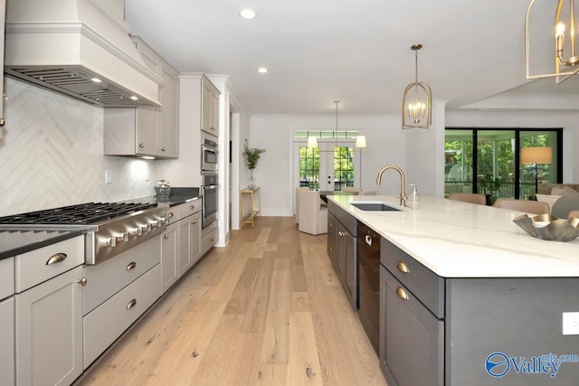 60 Trail Loop Rd, Huntsville, AL 35803 - kitchen with custom range hood, stainless steel gas cooktop, french doors, light wood-style flooring, and plenty of natural light