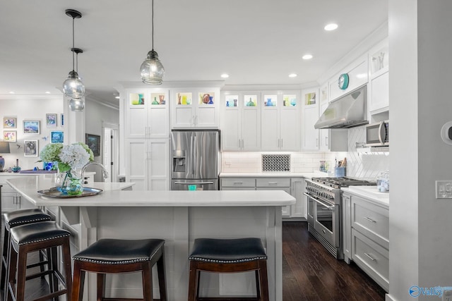 kitchen with stainless steel appliances, light countertops, white cabinets, under cabinet range hood, and tasteful backsplash