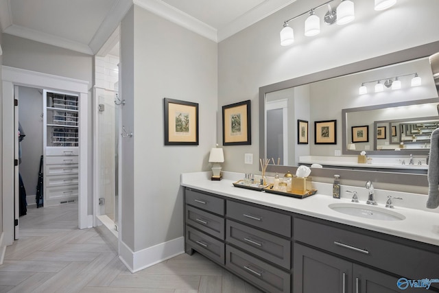 full bathroom featuring a stall shower, baseboards, ornamental molding, and vanity