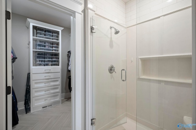 bathroom featuring a shower stall and a spacious closet