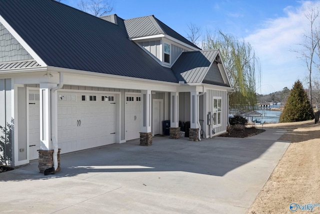 view of property exterior with metal roof, board and batten siding, concrete driveway, and a standing seam roof