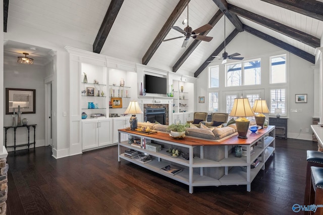 living area featuring baseboards, high vaulted ceiling, beam ceiling, a stone fireplace, and dark wood-type flooring