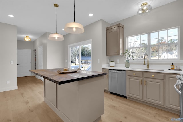 kitchen featuring butcher block counters, sink, a center island, light hardwood / wood-style flooring, and stainless steel dishwasher