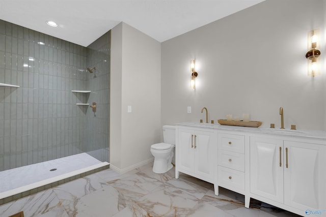 bathroom featuring vanity, toilet, and tiled shower