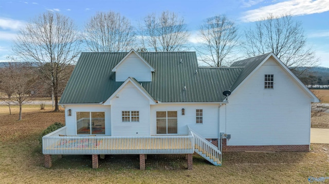 back of property with a lawn and a wooden deck