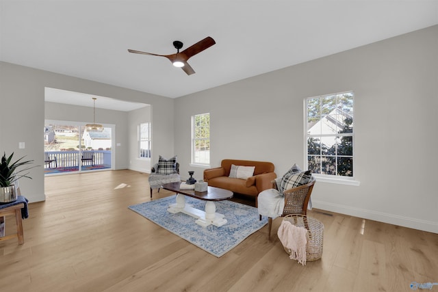 living room featuring ceiling fan, light hardwood / wood-style floors, and a healthy amount of sunlight