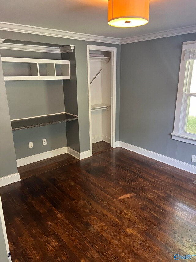 unfurnished bedroom with dark wood-type flooring and crown molding