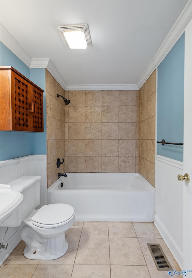 bathroom with toilet, crown molding, tiled shower / bath combo, and tile patterned flooring