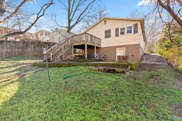 back of property with a lawn and a wooden deck