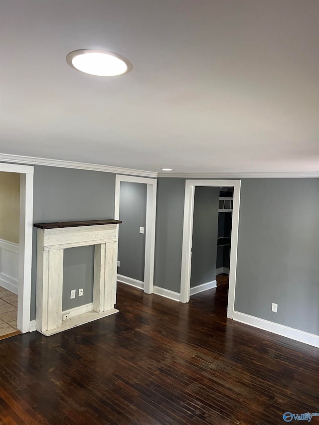 unfurnished living room featuring dark hardwood / wood-style flooring and ornamental molding