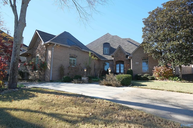 french country inspired facade with a front yard