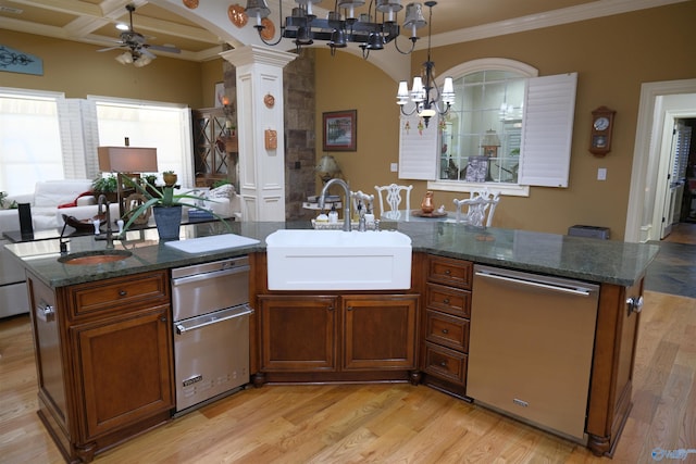 kitchen with ornate columns, dishwasher, sink, coffered ceiling, and an island with sink