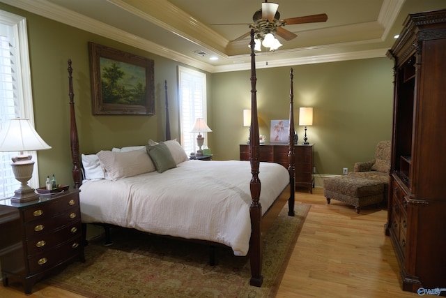 bedroom with a raised ceiling, ceiling fan, light hardwood / wood-style floors, and ornamental molding